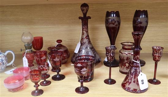 A collection of cranberry and engraved ruby glassware, including a decanter and stopper,